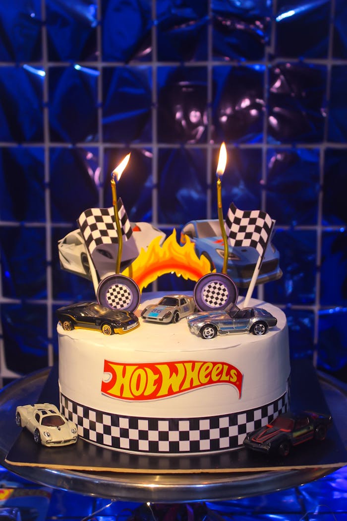 Vibrant Hot Wheels birthday cake with toy cars and checkered flags, perfect for celebrations.