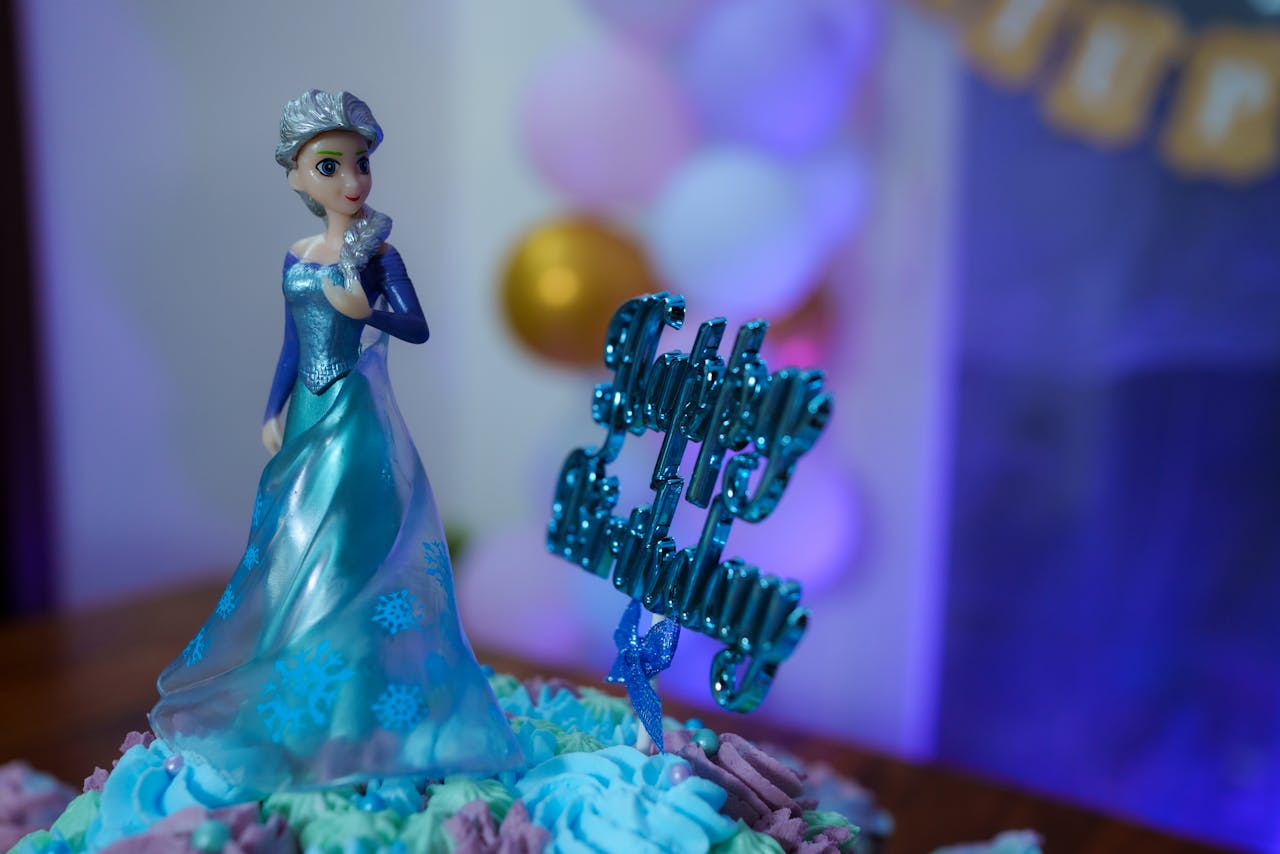 Beautiful Frozen themed birthday cake featuring a doll topper and vibrant decorations, perfect for childrens parties.