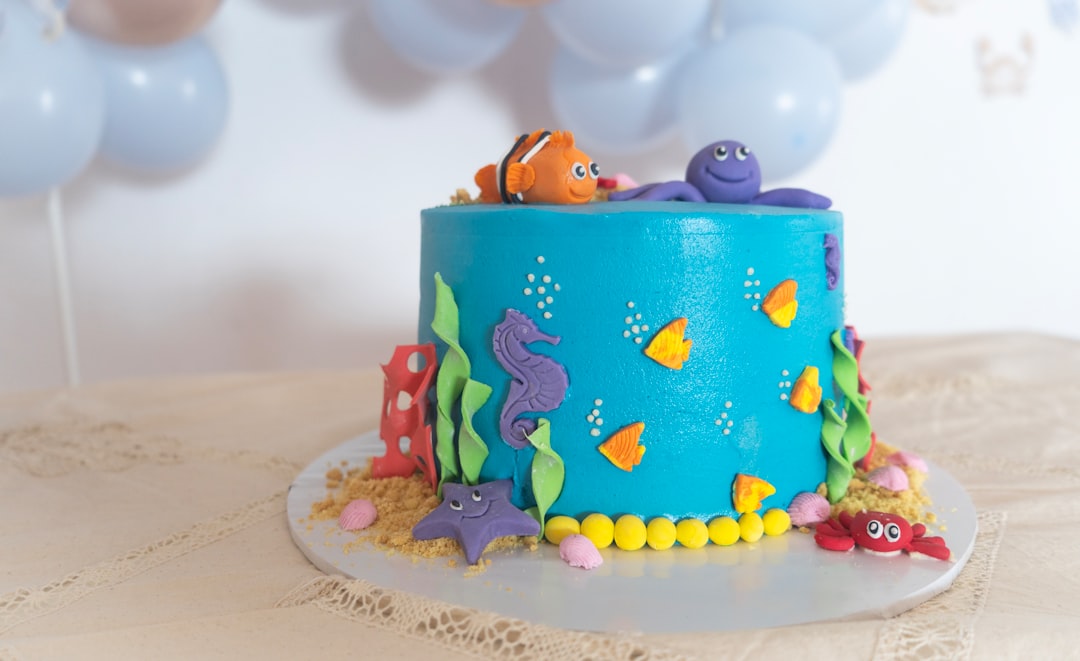 An underwater ocean theme birthday cake with blue icing decorated with sea creatures.